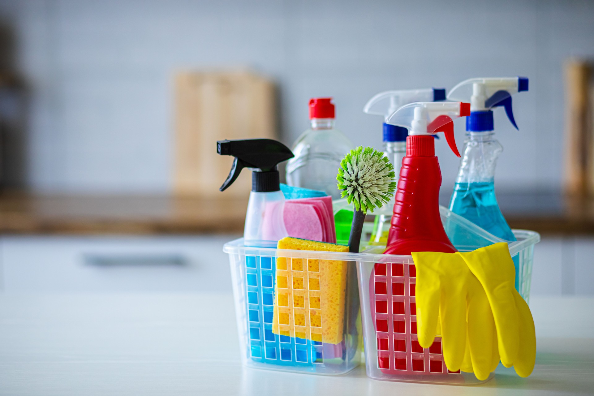 Colorful Cleaning Supplies in Modern White Kitchen for Home Hygiene and Sanitation